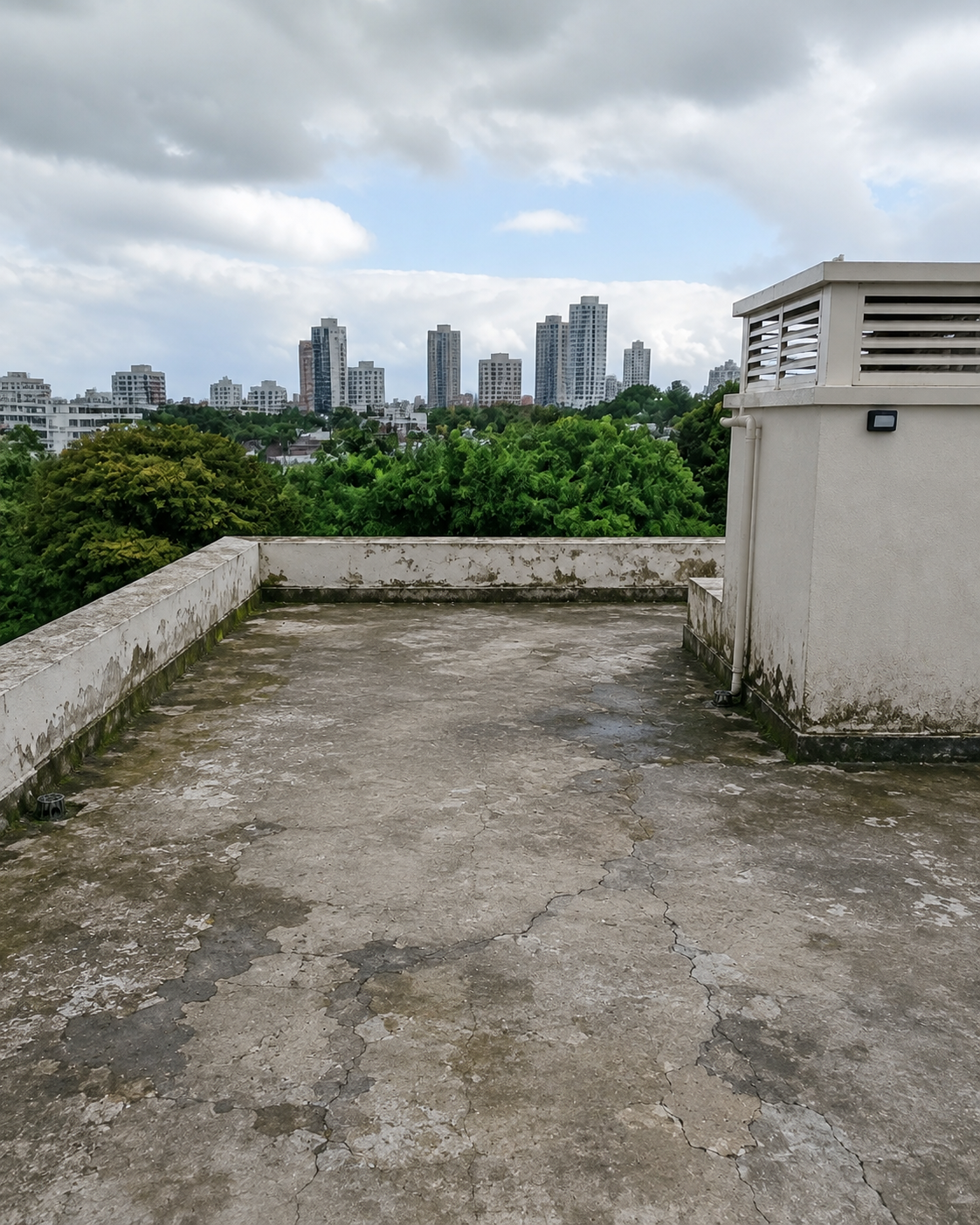 The same rooftop before treatment: cracked, stained concrete